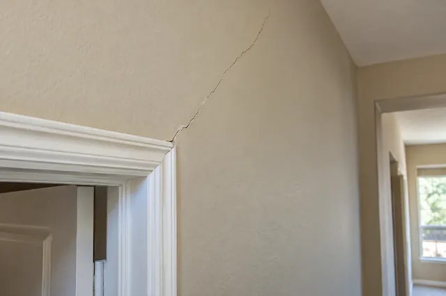 Diagonal cracks off the corners of doors and windows are the classic sign of slab movement.